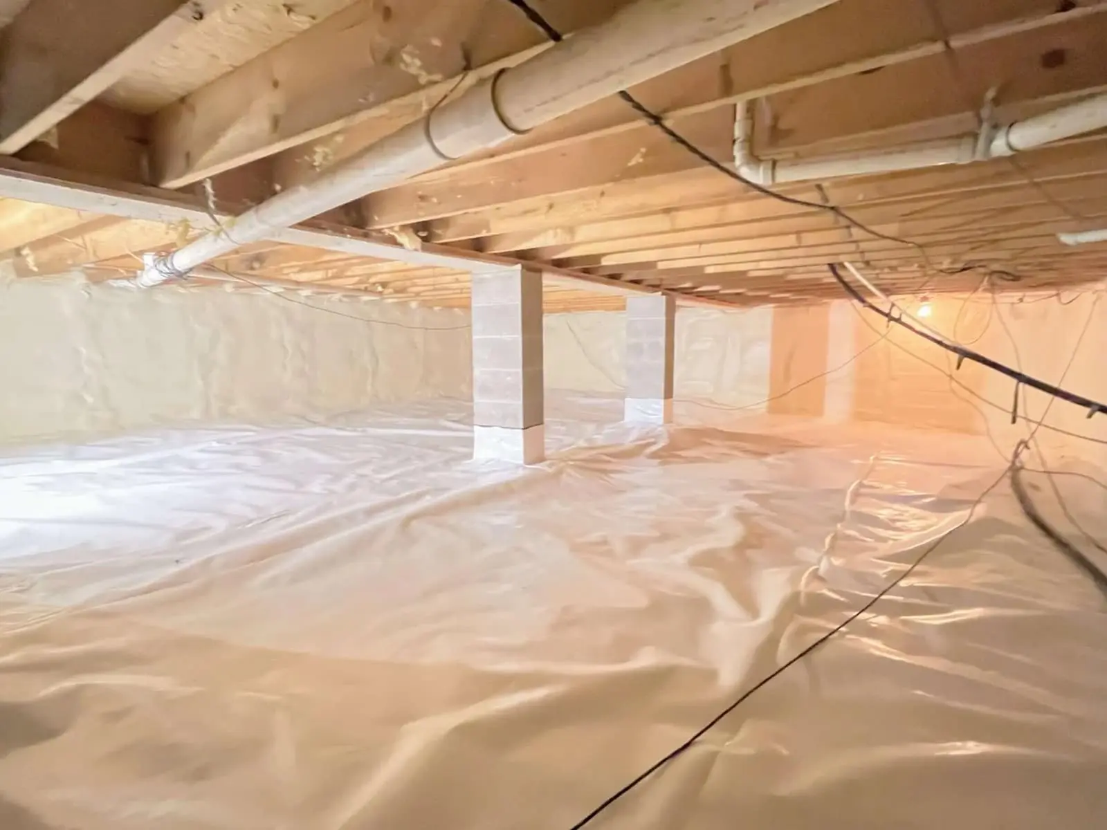 Fully encapsulated crawl space with a sealed liner on the floor and walls in an Ontario home.